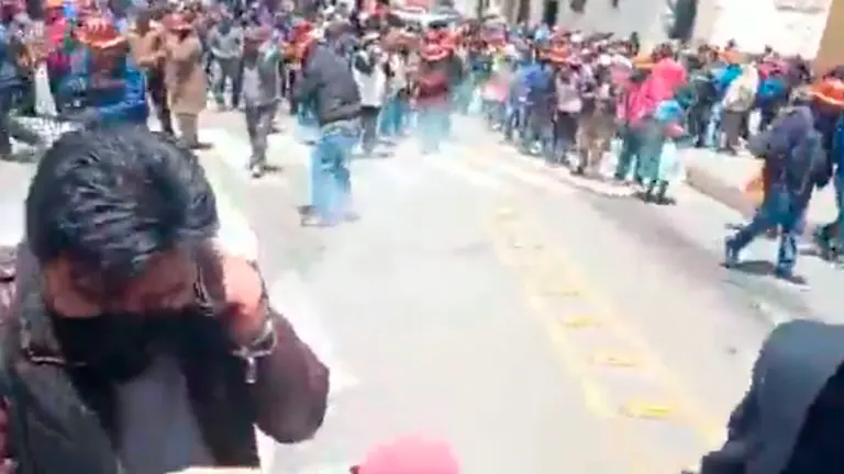 Periodistas tratan de protegerse frente al estallido de dinamita lanzada por mineros cooperativistas de Potos&iacute;. CAPTURA DE VIDEO