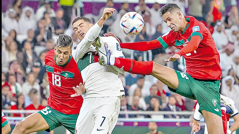Cristiano Ronaldo (c) pugna la posesión del balón con dos jugadores marroquíes. EFE