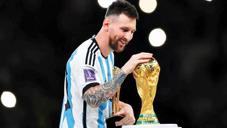 Lionel Messi toca la copa que levant&oacute; en Catar 2022. EFE