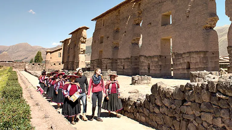 Turistas y comunarios pasean por las ruinas de un pueblo peruano llamado Raqchi.