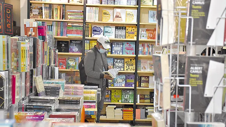 Un lector busca libros en Kronos, la librería que está organizando la muestra literaria. NOÉ PORTUGAL