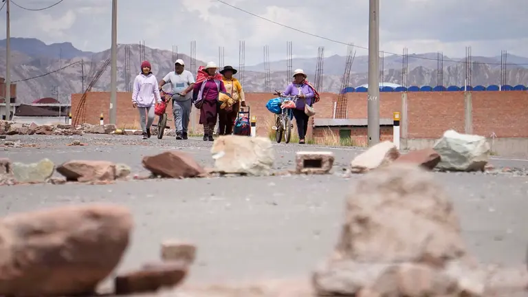 Personas caminan por una calle bloqueada en el lado peruano de la poblaci&oacute;n de Desaguadero, en la frontera con Bolivia, en una fotograf&iacute;a de archivo. EFE