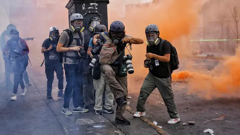 Fotorreporteros y miembros de la prensa cubren los enfrentamientos entre manifestantes y la Polic&iacute;a durante una jornada de protestas antigubernamentales, en Lima (Per&uacute;). EFE