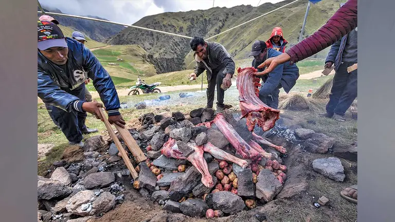 Comunarios de Cocapata ponen carne de llama sobre las piedras calientes. DICO SOLÍS