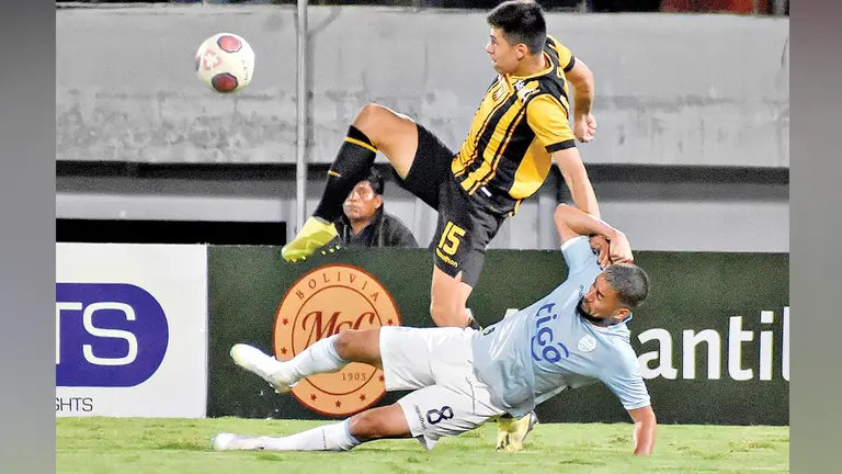 Rodrigo Ramallo pugna un balón con Matías Claure, durante el 1-1 de Aurora ante The Strongest en Cochabamba. DICO SOLÍS