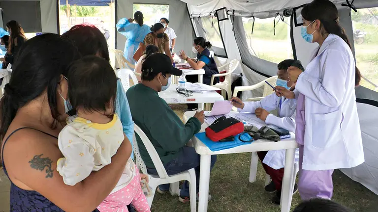 Personas esperan para recibir atención médica en un hospital móvil contra el dengue. EFE