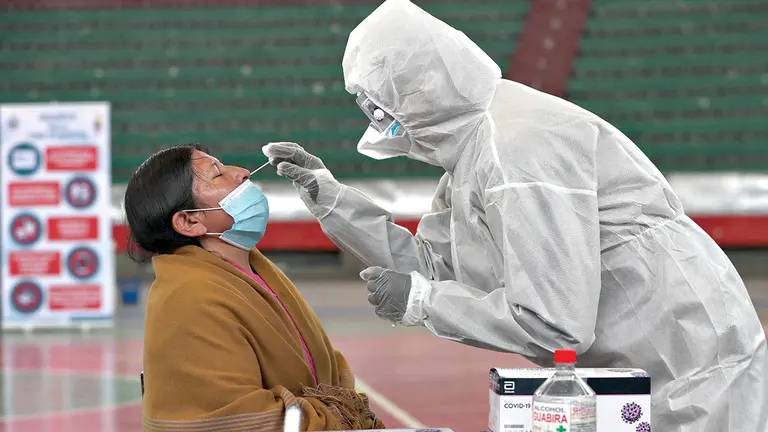 Un funcionario del SEDES realiza una prueba de covid-19 a una persona en La Paz. EFE