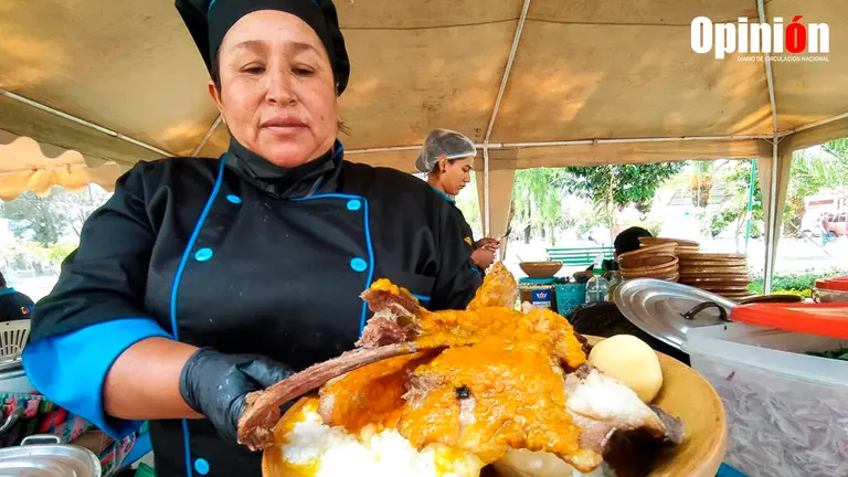 Cocinera muestra un plato de Puchero en la feria de las costumbres carnavaleras./ DICO SOL&Iacute;S
