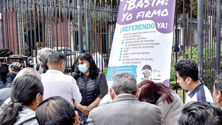 Personas firman los libros dispuestos por los denominados juristas independientes./ NO&Eacute; PORTUGAL
