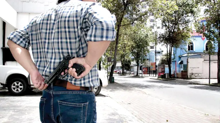 Un sujeto portando un arma tras obtener la licencia, en Ecuador. / HENRY LAPO (EXTRA.EC)