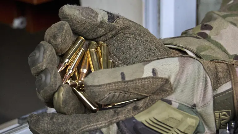 Imagen referencial sobre balas, sujetadas por un militar./ EFE