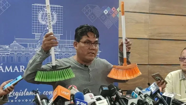 El diputado H&eacute;ctor Arce muestra las escobas que tiene listas para d&aacute;rselas a CC y a Creemos. ERBOL