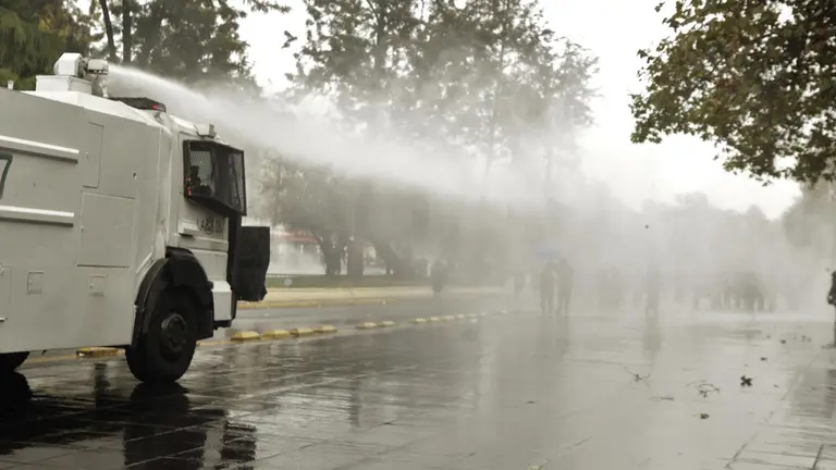 Un veh&iacute;culo laza agua de la polic&iacute;a chilena, se enfrenta con j&oacute;venes durante una manifestaci&oacute;n estudiantil, el 12 de abril de 2023, en Santiago (Chile)./ EFE