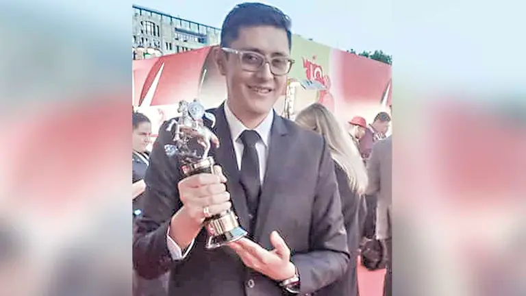 Alejandro Quiroga sostiene el galard&oacute;n que obtuvo el actor Fernando Arze Echalar./ FACEBOOK