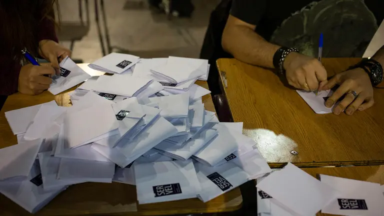 Personas firman los votos para el conteo en el centro de votaci&oacute;n Estaci&oacute;n Mapocho, en la comuna de Santiago Centro, para las elecciones del Consejo Constitucional este 20 de mayo de 2023, en Santiago (Chile)./ EFE