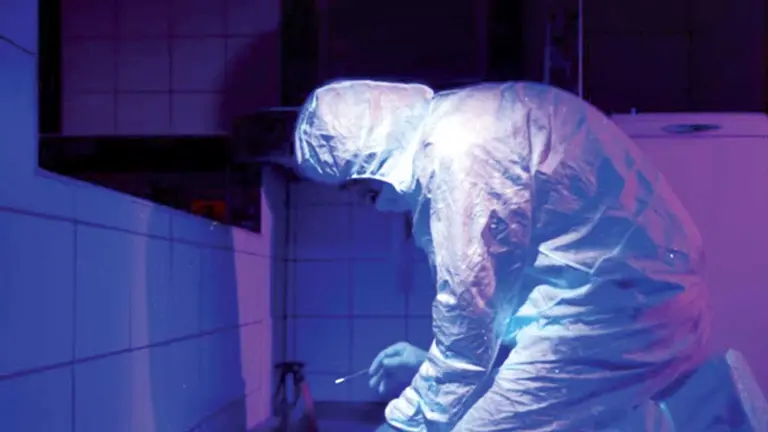 Un perito realiza pruebas de luminol en el edificio Ambassador, donde estuvo sus últimas horas Carlos Alberto Colodro./ CAPTURA DE PANTALLA