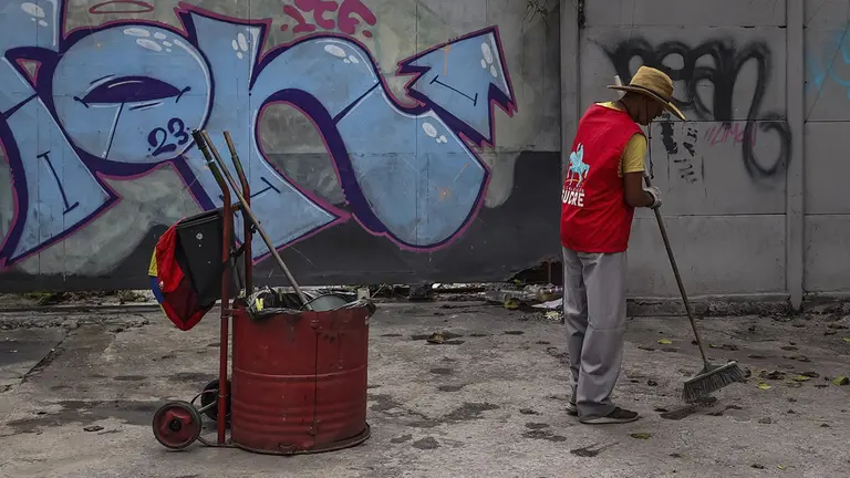 Un hombre barre en una calle en Caracas (Venezuela)./ EFE