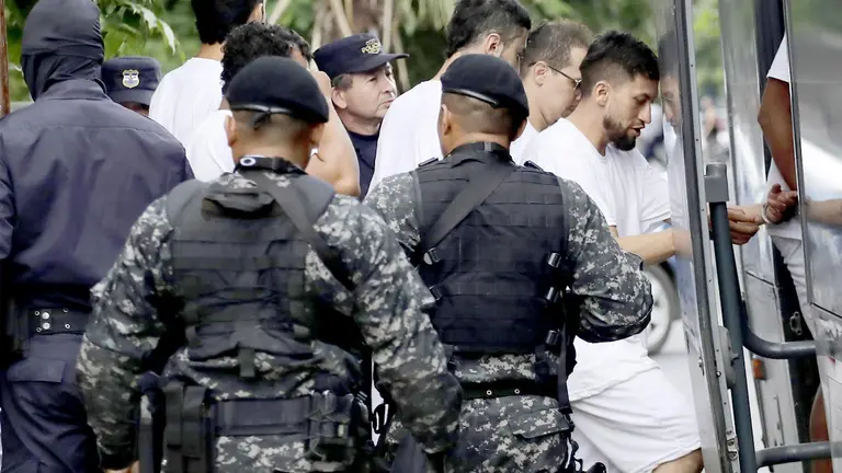 Un grupo de colombianos y salvadore&ntilde;os, se&ntilde;alados de pertenecer a una organizaci&oacute;n delictiva "trasnacional" son trasladados a una penitenciar&iacute;a, en San Salvador (El Salvador)./ EFE