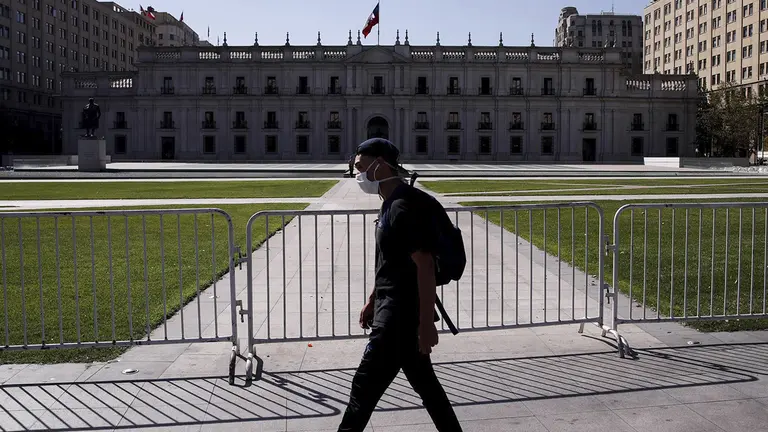 Un hombre camina usando mascarilla frente al Palacio de la Moneda de Santiago (Chile), en una fotograf&iacute;a de archivo./ EFE