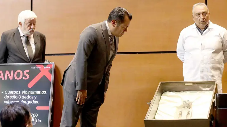 Fotografía cedida, por la Cámara de Diputados, del investigador del fenómeno OVNI Jaime Maussan (i) y del diputado Sergio Carlos Gutiérrez (c) mientras observan el cuerpo de un presunto extraterrestre./ EFE