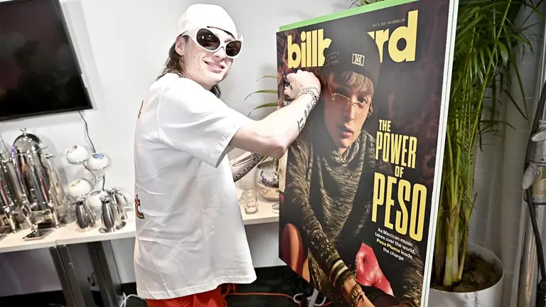 Fotografía cedida por Billboard donde aparece el cantante mexicano Peso Pluma mientras firma un cartel de Billboard con su imagen en Miami Beach, Florida (EEUU)./ EFE