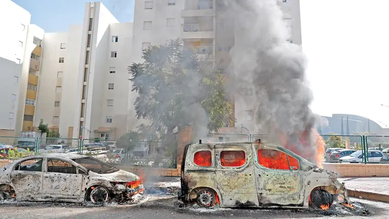 Vehículos quemados en la ciudad israelí de Ashkelon tras lanzamientos de cohetes desde Gaza.  / EFE