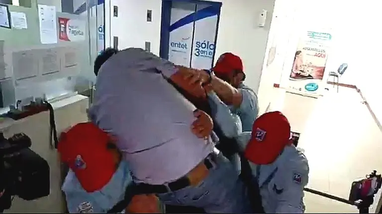 El diputado, H&eacute;ctor Arce, intenta ingresar a Entel trepando un torniquete. RRSS