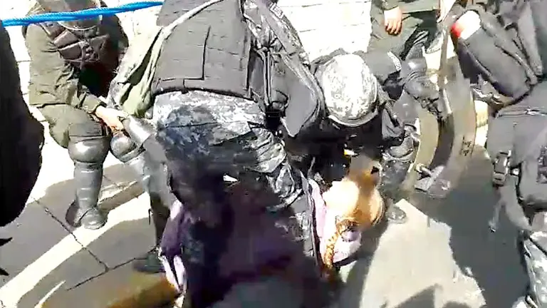 Una mujer cae al piso durante la intervenci&oacute;n policial./ ERBOL