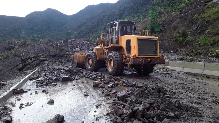 Un tractor trabaja en quitar lodo tras los deslizamientos. ABC