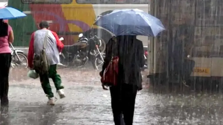 Personas caminan por una calle de Cochabamba protegi&eacute;ndose de la lluvia. ARCHIVO
