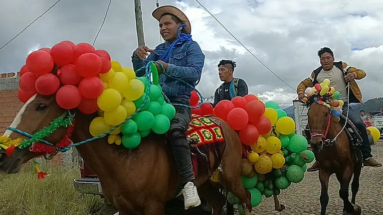 J&oacute;venes montados en caballos adornados con globos visitan a sus vecinos en Candelaria, Colomi. MARIELA COSS&Iacute;O