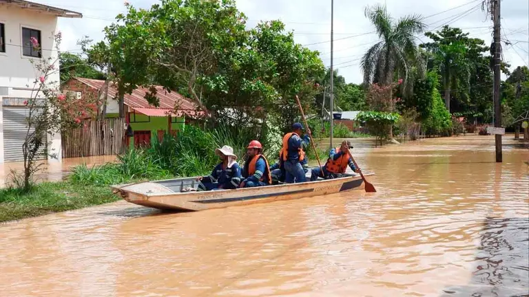 Los funcionarios de ENDE se trasladan en canoas hacia una vivienda inundada en Cobija. ENDE