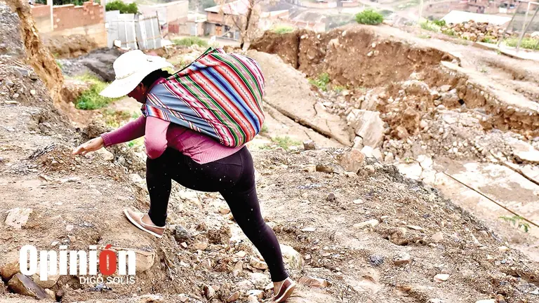 Una vecina camina en Takoloma, en un sector donde antes era una calle./ DICO SOL&Iacute;S