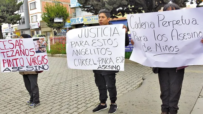Un grupo de personas exige, con carteles, sanciones dr&aacute;sticas contra un infanticida./ APG