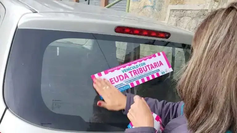 Alcaldía paceña pega stickers en vehículos con deuda tributaria./ GAMLP