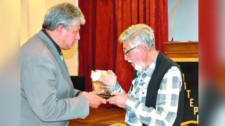 El rector de Unitepc, Eduardo Mancilla, da un galardón al maestro Alberto Villalpando./ NOÉ PORTUGAL