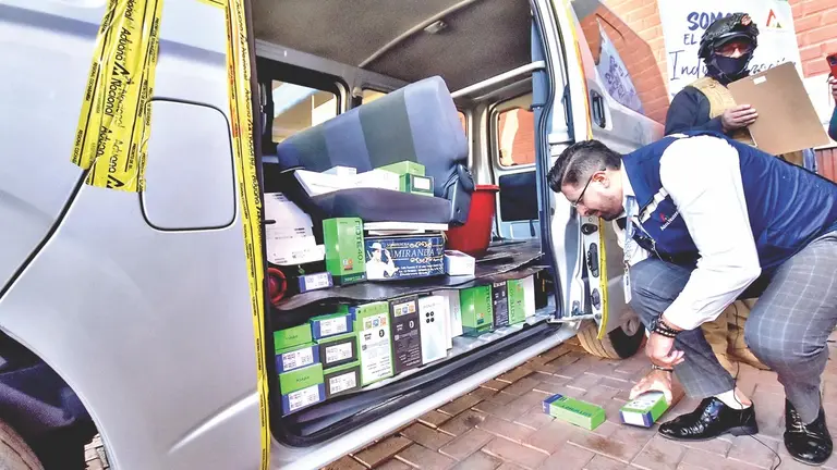 El Gerente Regional de la Aduana muestra las cajas de celulares camufladas en el trufi, este 18 de abril./ DICO SOLÍS