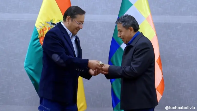 El presidente Luis Arce (i) le entrega