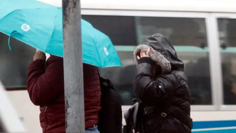 Dos personas se cubren de la lluvia en Santa Cruz. APG
