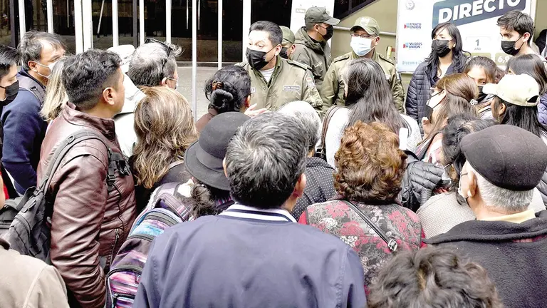 Ciudadanos bolivianos, en las afueras de una entidad bancaria./ INFOBAE