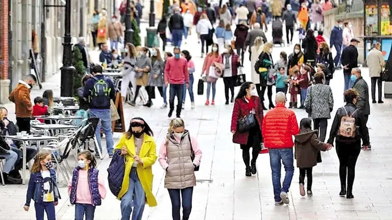 Un grupo de personas camina por una calle de España./ INFOBAE