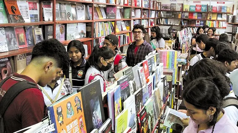 Un grupo de lectores seleccionan obras en la muestra ferial literaria cruceña./ PORTAL VERDE