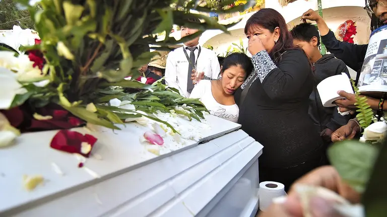 Familiares junto a la caja fúnebre de Marbella./ NOÉ PORTUGAL