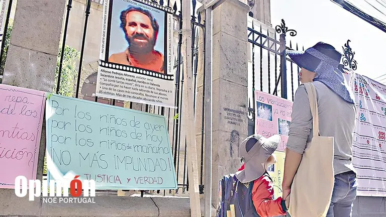 Una mujer y su hijo observan carteles puestos en el templo de la Compañía de Jesús en  Cochabamba./ NOÉ PORTUGAL