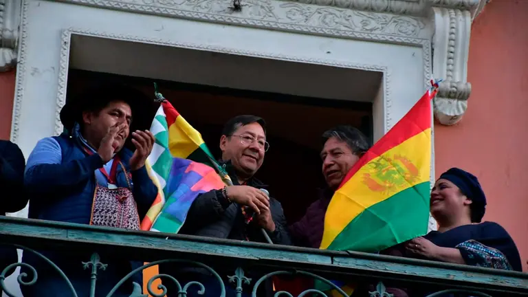 El presidente del Estado, Luis Arce, junto a parte de su gabinete sonriendo mirando a los ciudadanos en la Plaza Murillo./ APG