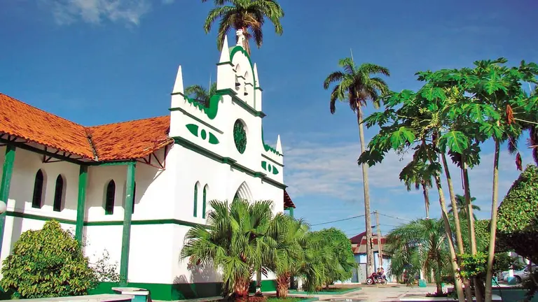 Esta iglesia se encuentra a pocos metros del río Acre, en la cima plana de una colina. Para llegar a ella se pasa por una alameda de palmeras./ SKYSCRAPER