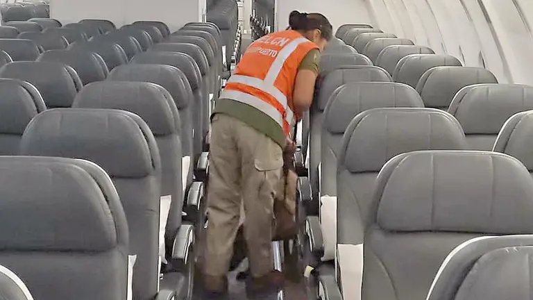 Fotograf&iacute;a del momento en que una oficial, acompa&ntilde;ada por un perro antidrogas, 
revisa el avi&oacute;n en Viru Viru./ FACEBOOK JAIME MAMANI