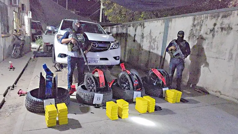 Personal de la FELCN presenta la camioneta y los paquetes de droga hallados en las llantas./ FELCN