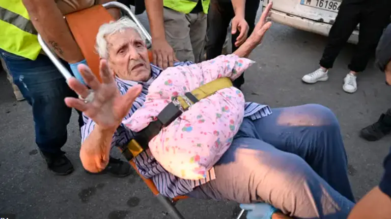 Un civil es socorrido por los voluntarios./ EPA