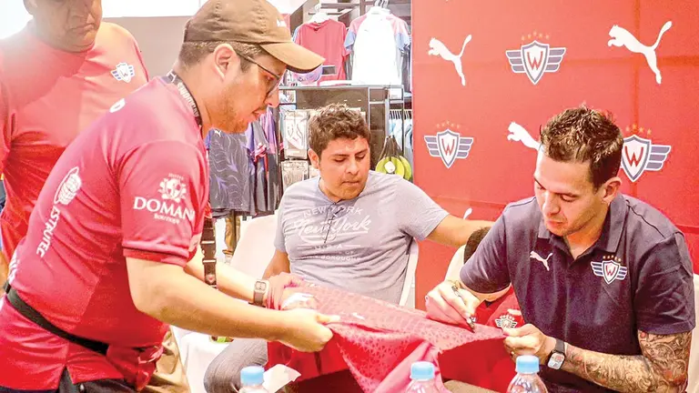 Pipo Gim&eacute;nez firma una casaca para un hincha./ CLUB DEPORTIVO JORGE WILSTERMANN